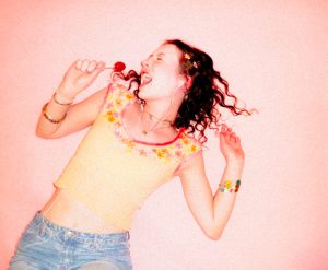 model posing with lollipop mircrophone with pink background