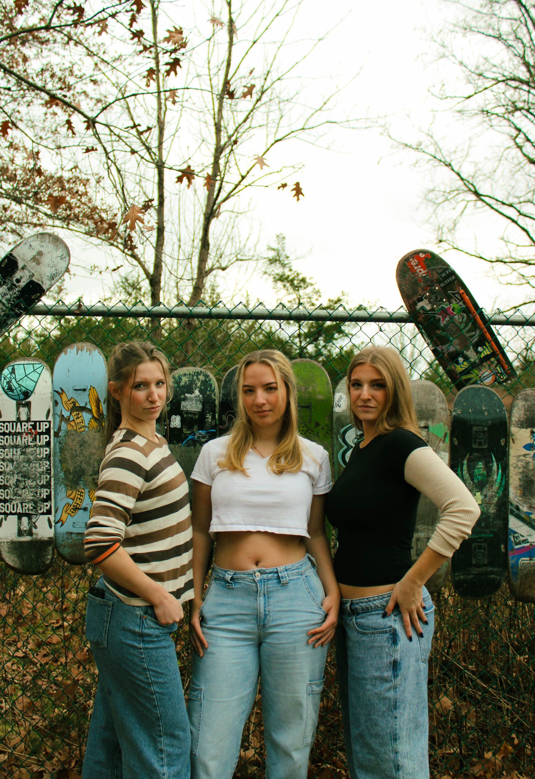 3 models posing with skateboard wall