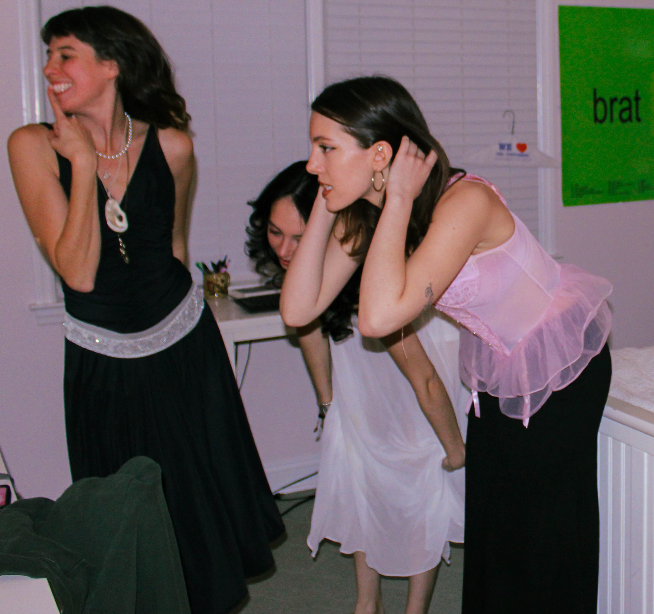 3 models playing dress in front of the mirror