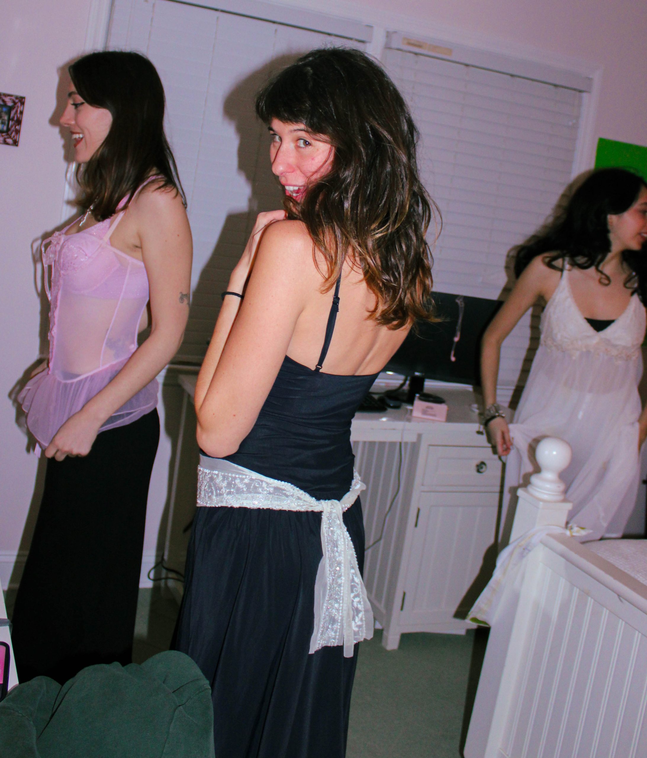 3 models playing dress in front of the mirror