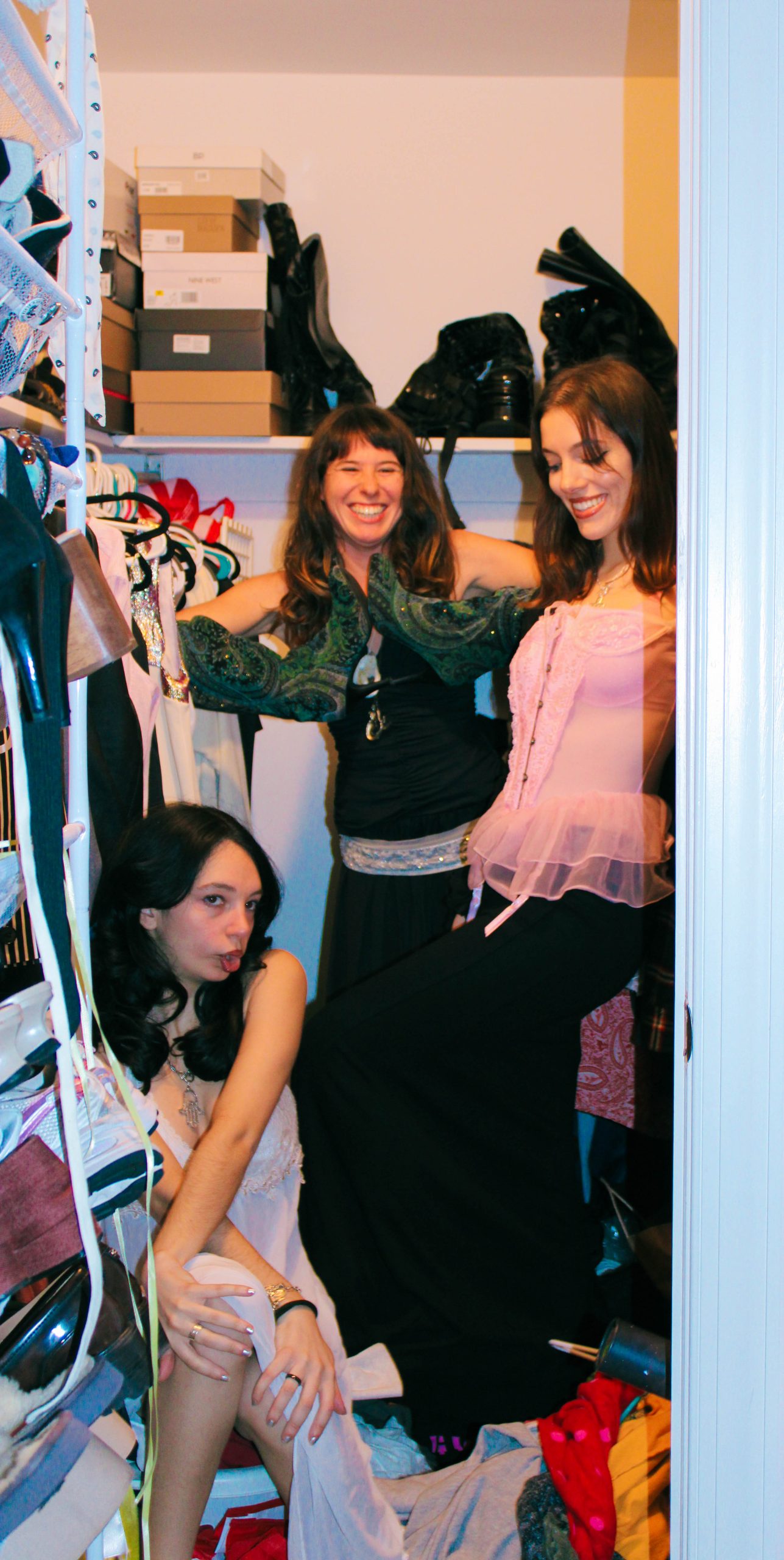 3 models playing dress up in a closet