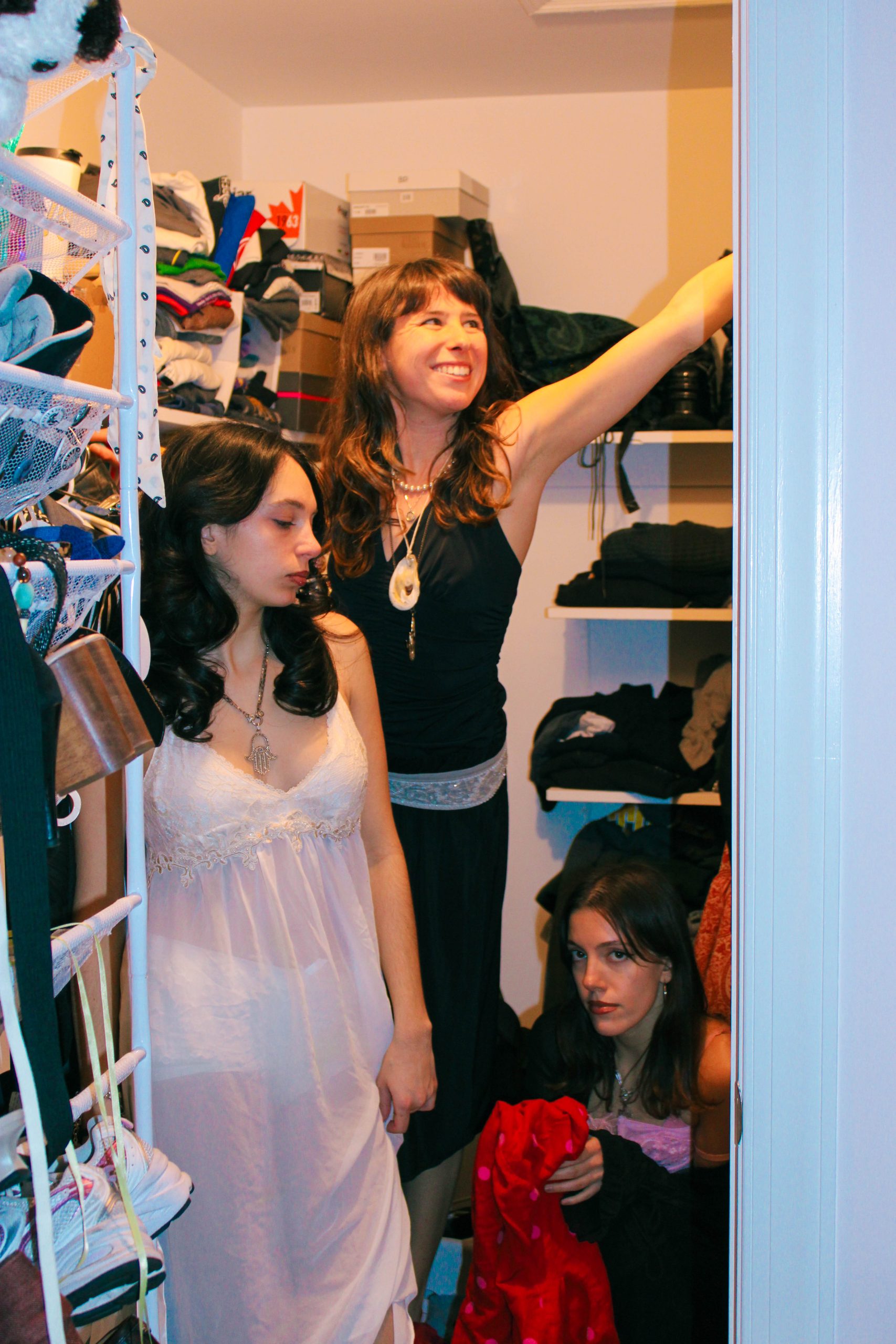 3 models playing dress up in a closet