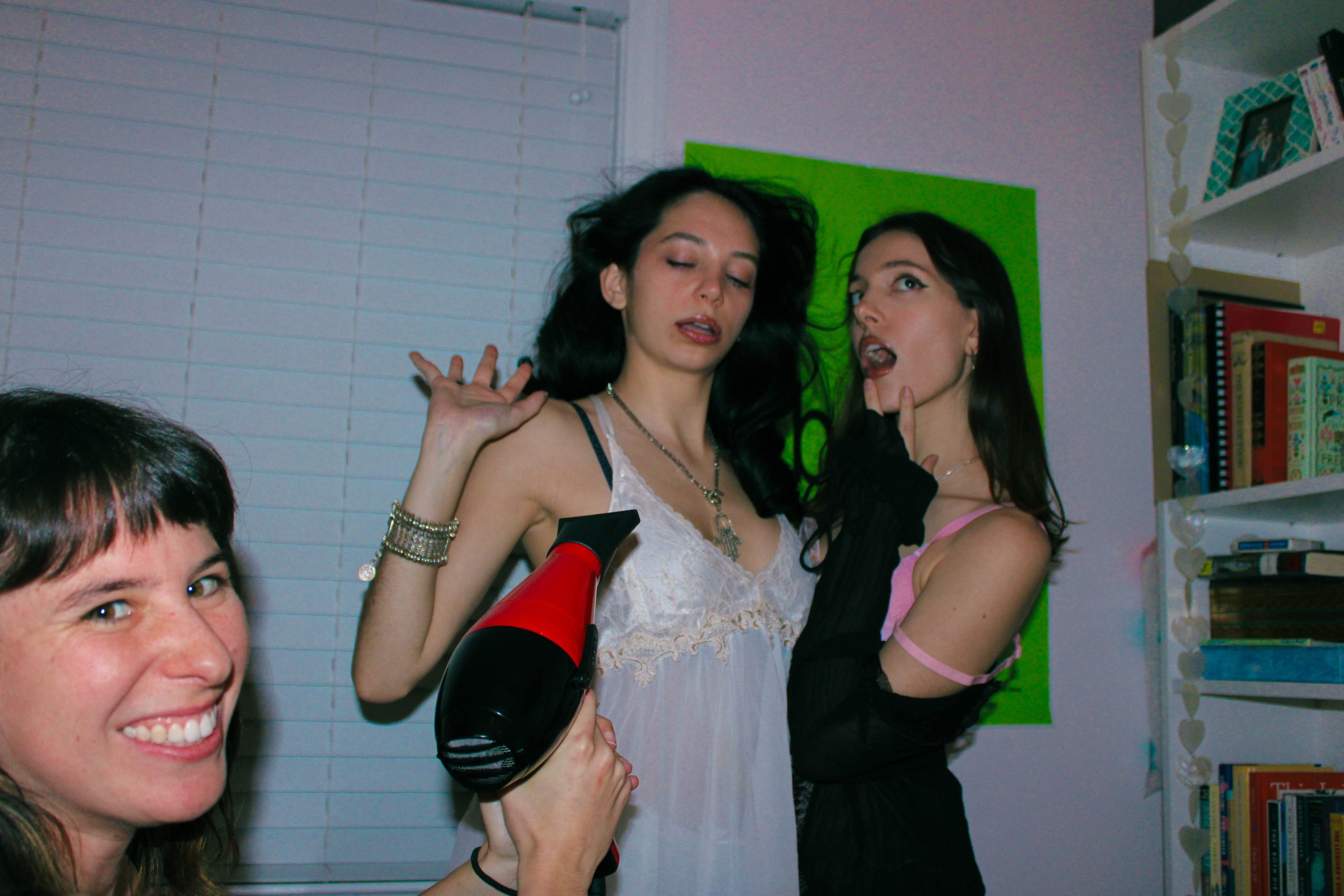 3 models posing using the hair drying as a wind machine