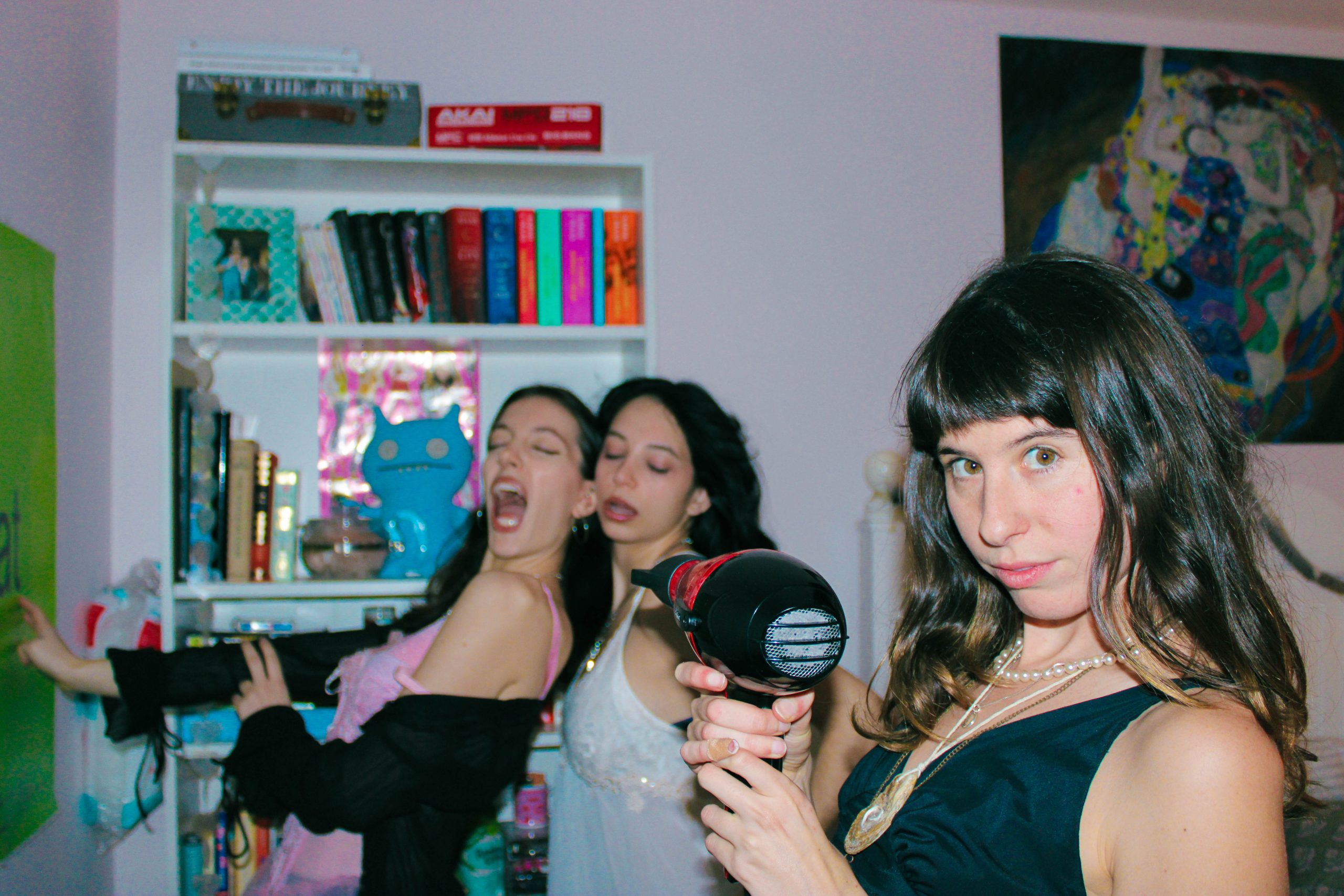 3 models posing using the hair drying as a wind machine